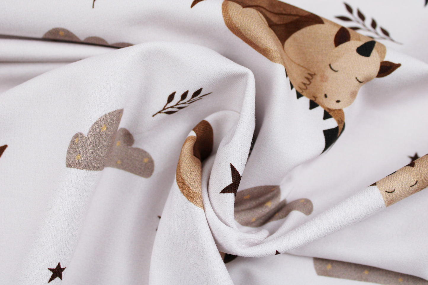 Weißer Baumwolljersey für Kinderbekleidung mit schlafendem Drachen Jo gedreht