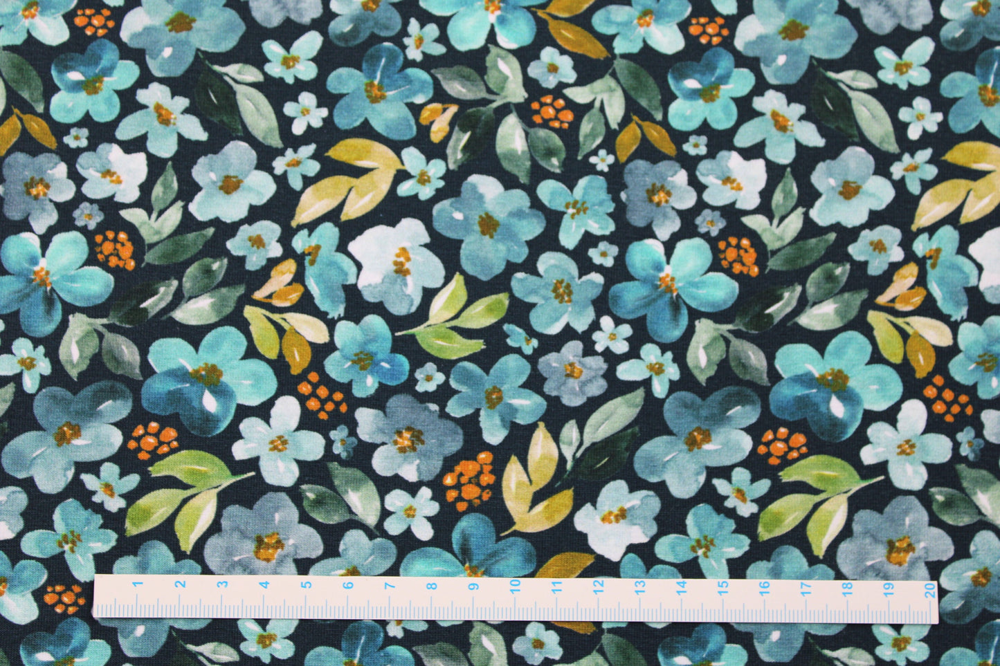 Petrolfarbener Baumwolljersey Elias mit Blümchen in mint und türkis Maßstab