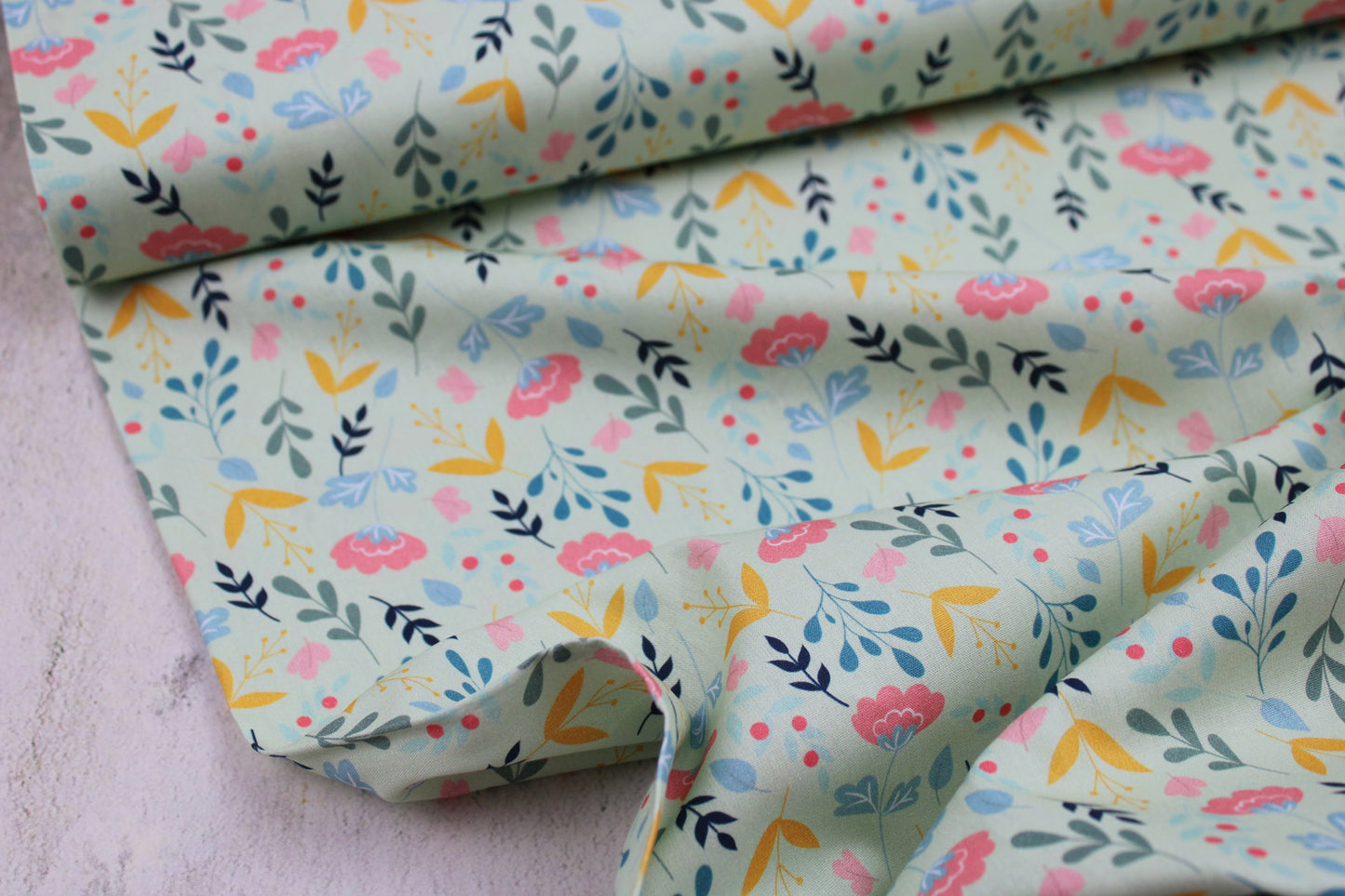 Baumwollstoff Spring mit bunten Blumen auf hellgrünem Grund Ballenansicht