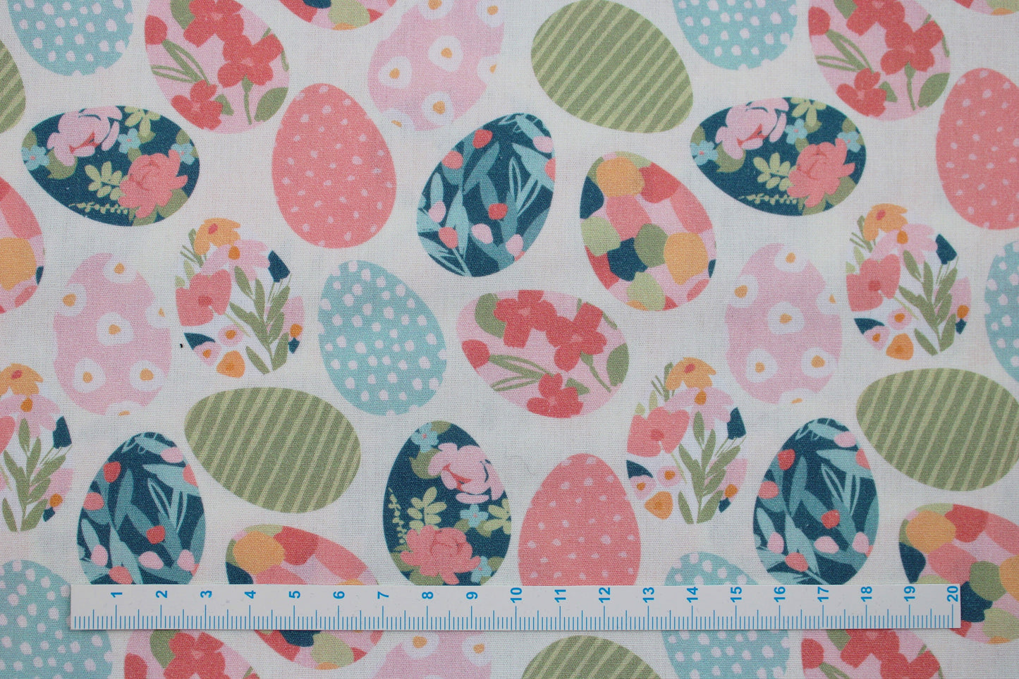 Weißer Baumwollstoff mit bunten Ostereiern Maßstab