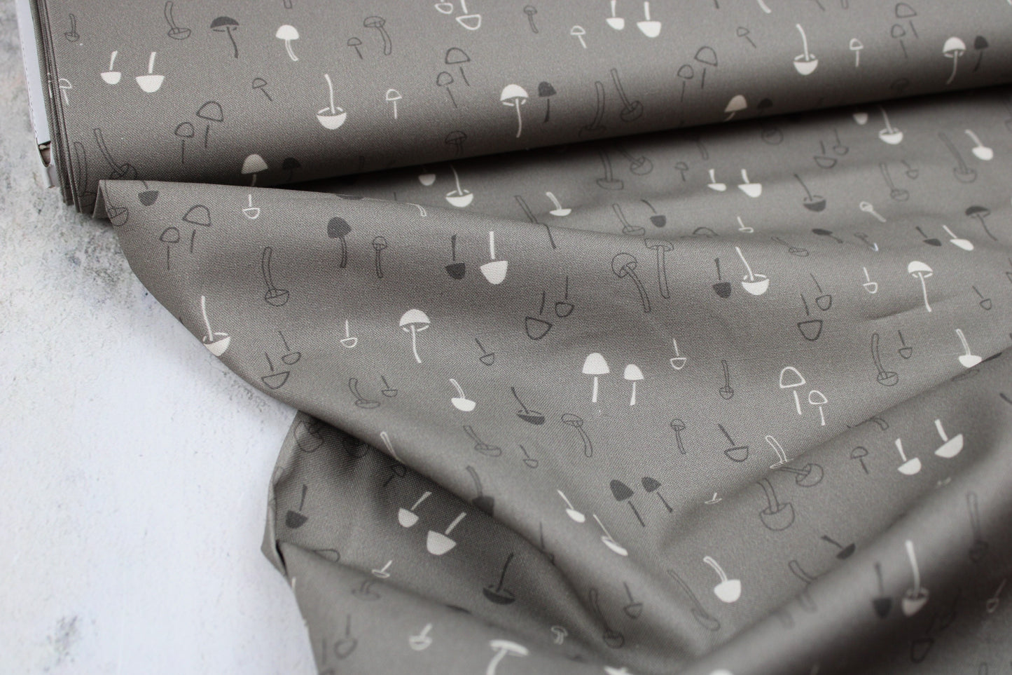 Baumwollstoff mit Pilzen in taupe aus der Serie Forest Tales Ballenansicht