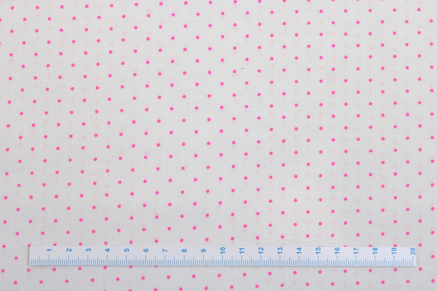 Wollweißer Baumwollstoff True Colors Tiny Dots mit Pink farbenen Punkten Maßstab