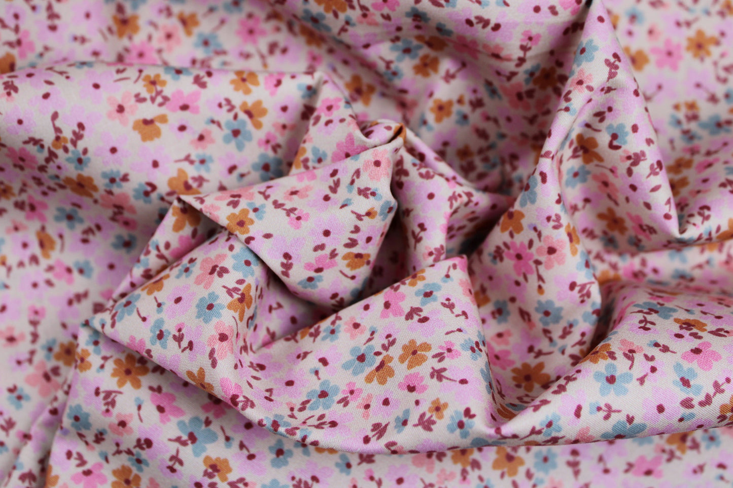 Leichter Baumwollstretch mit Millefleur-Muster in rosa-ecru gedreht