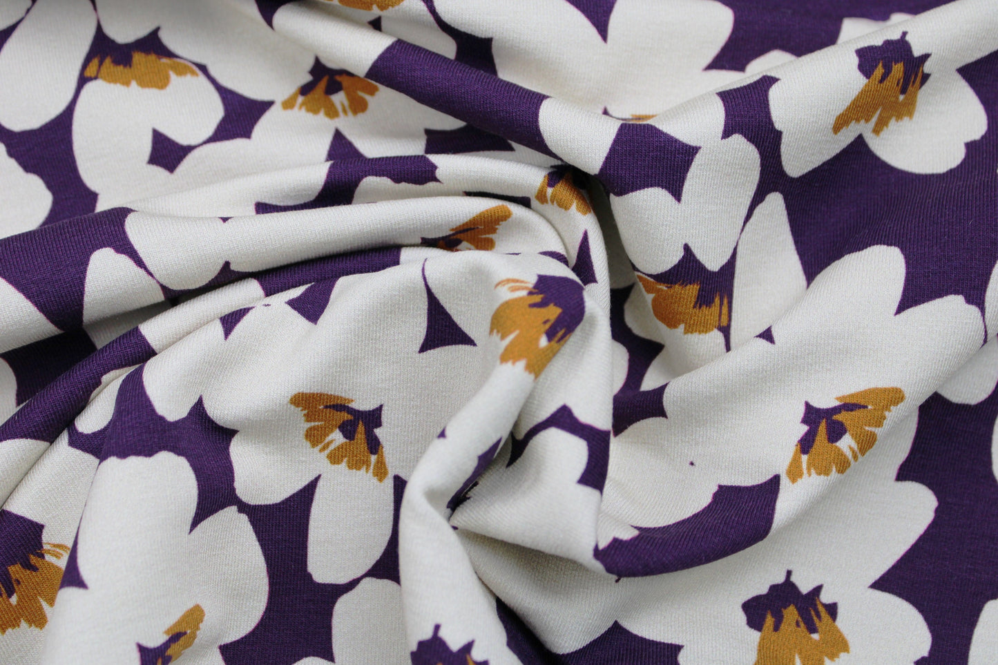 Modal French Terry Sweat in dunkellila mit ecru farbenen Blumen gedreht