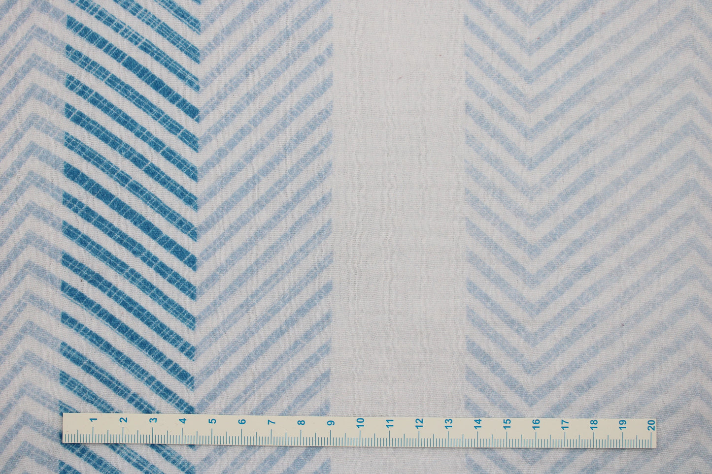 Weißer Musselinstoff mit blauen Chevron-Streifen Maßstab