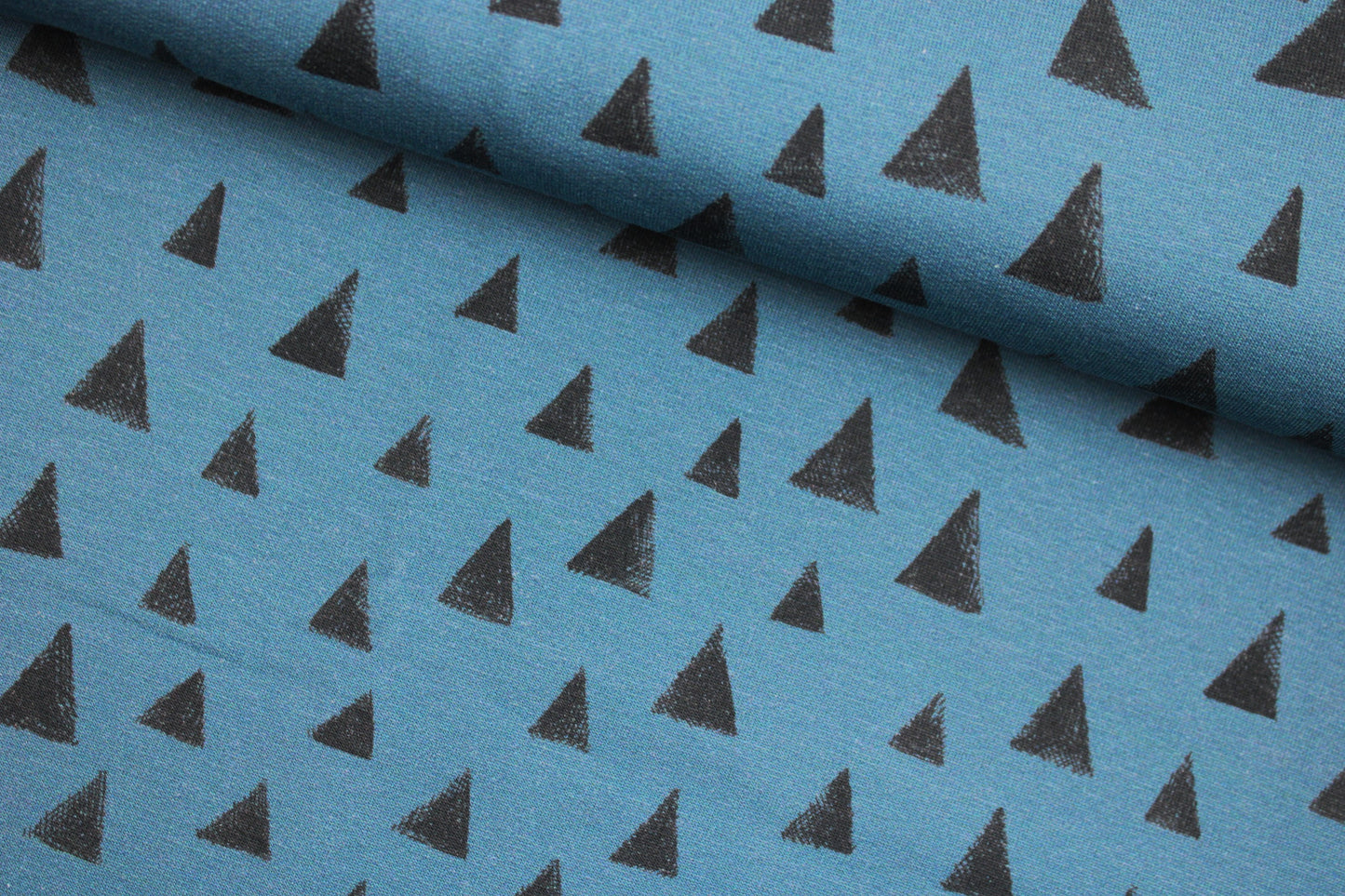 Blauer Sweatstoff mit grauen Dreiecken quer