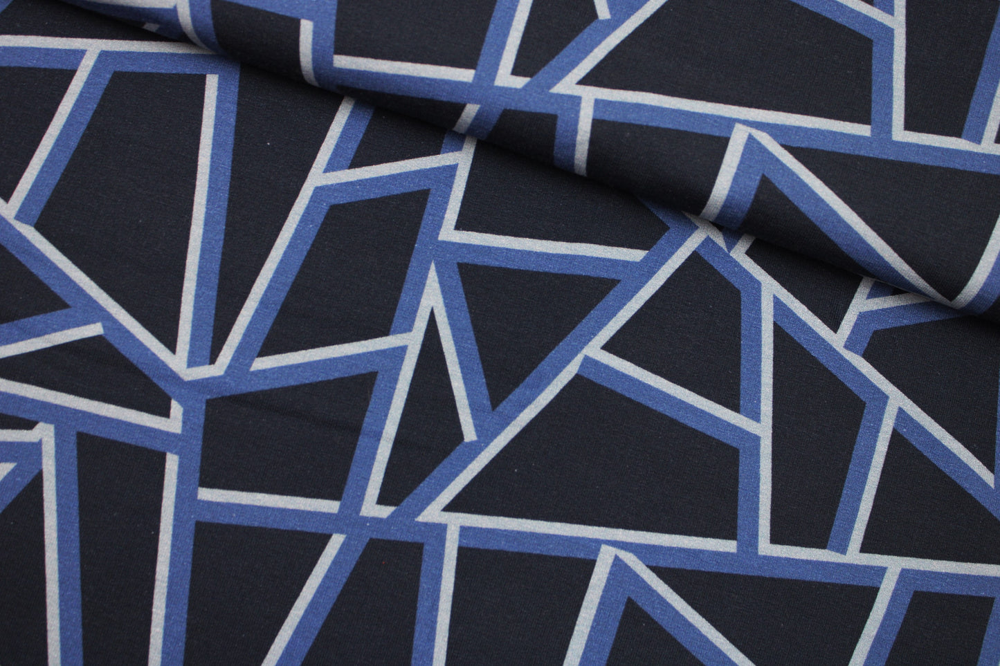 Dunkelblauer Sweatstoff mit blauen geometrischen Mustern quer