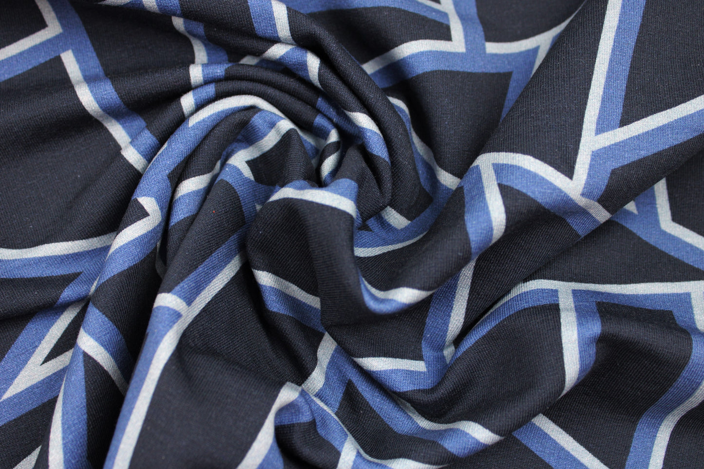 Dunkelblauer Sweatstoff mit blauen geometrischen Mustern gedreht