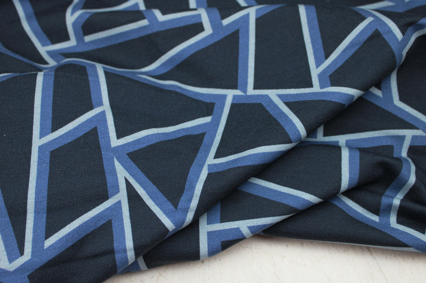 Dunkelblauer Sweatstoff mit blauen geometrischen Mustern