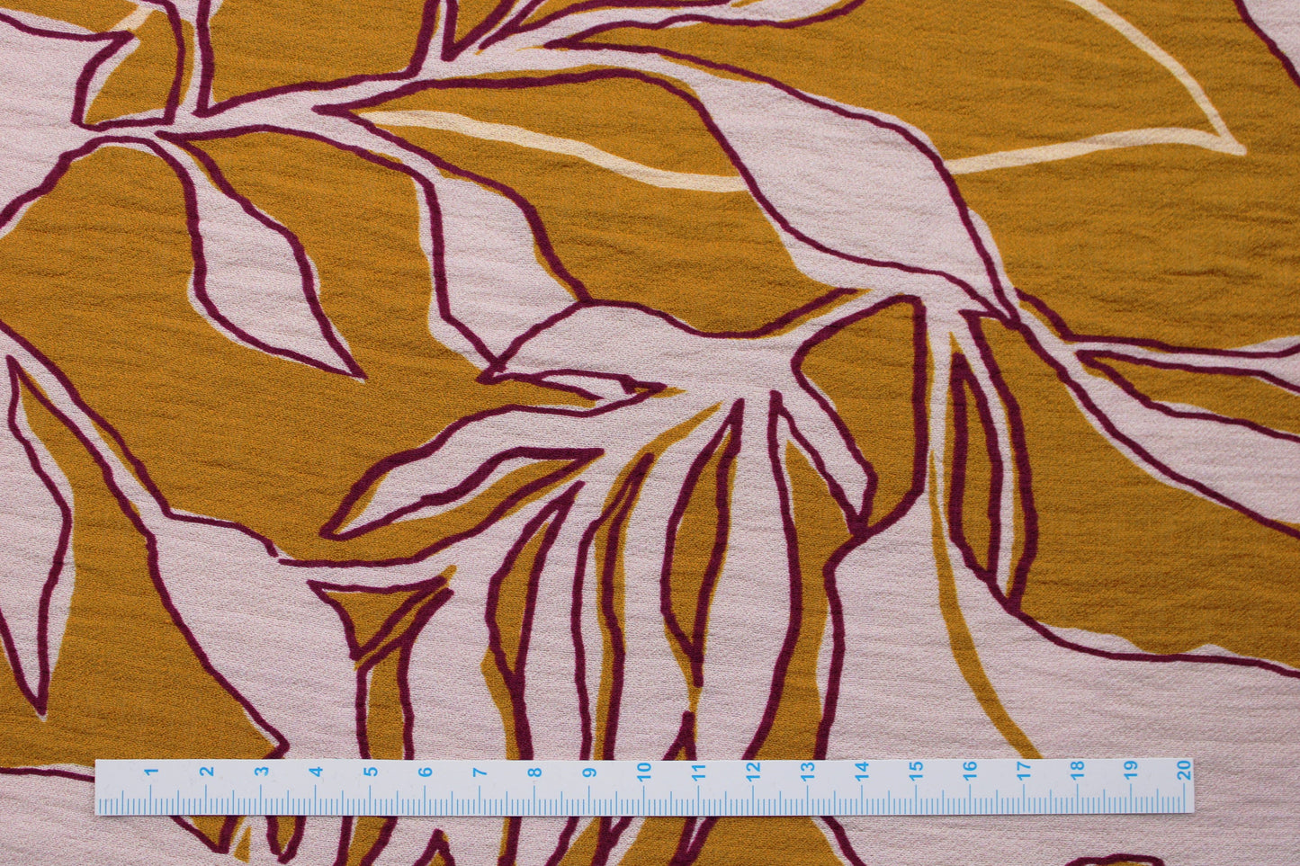 Gecreppter Viskosestoff mit großem Blumenmuster in nude/ocker Maßstab