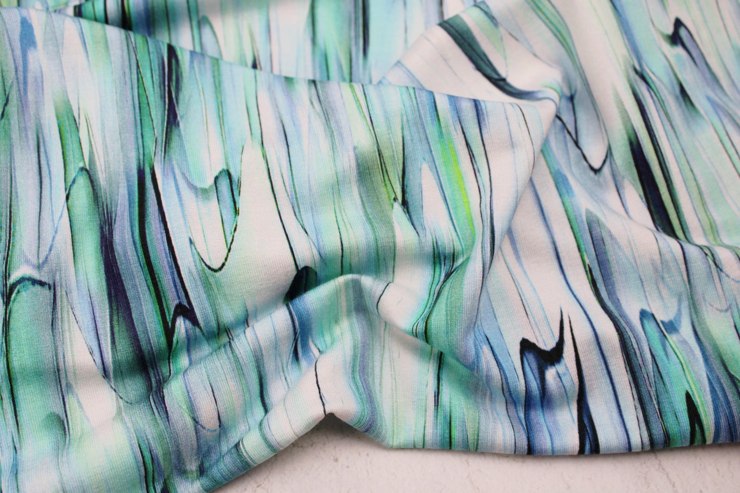 Viskosejersey mit abstrakten Linien in weiß, mint und blau