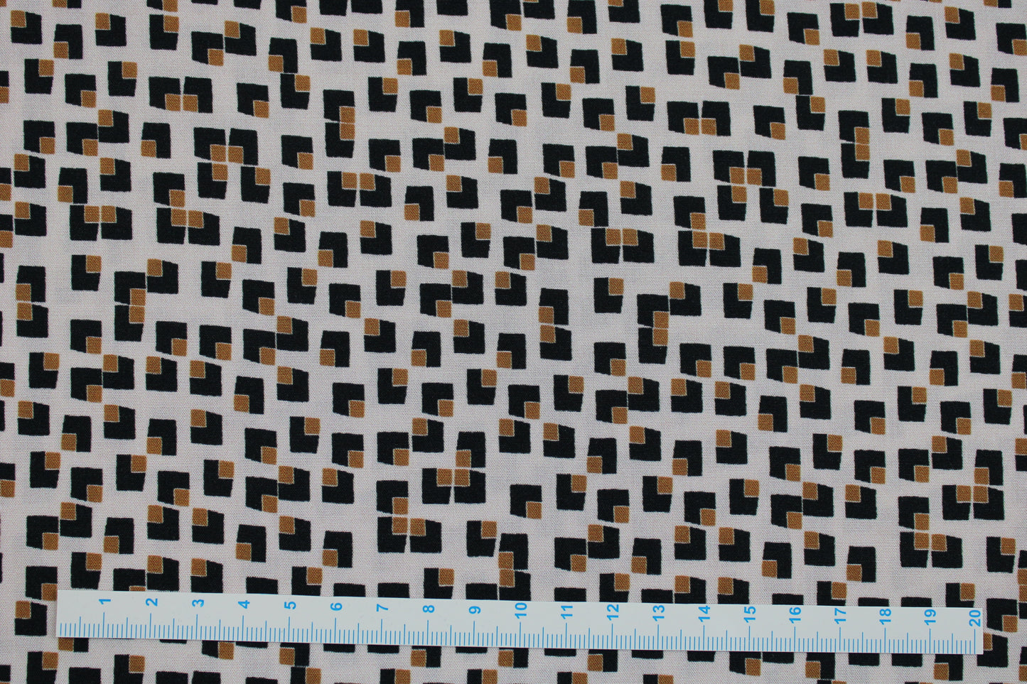 Beiger Viskosestoff mit kleinen Karos in schwarz-ocker Maßstab