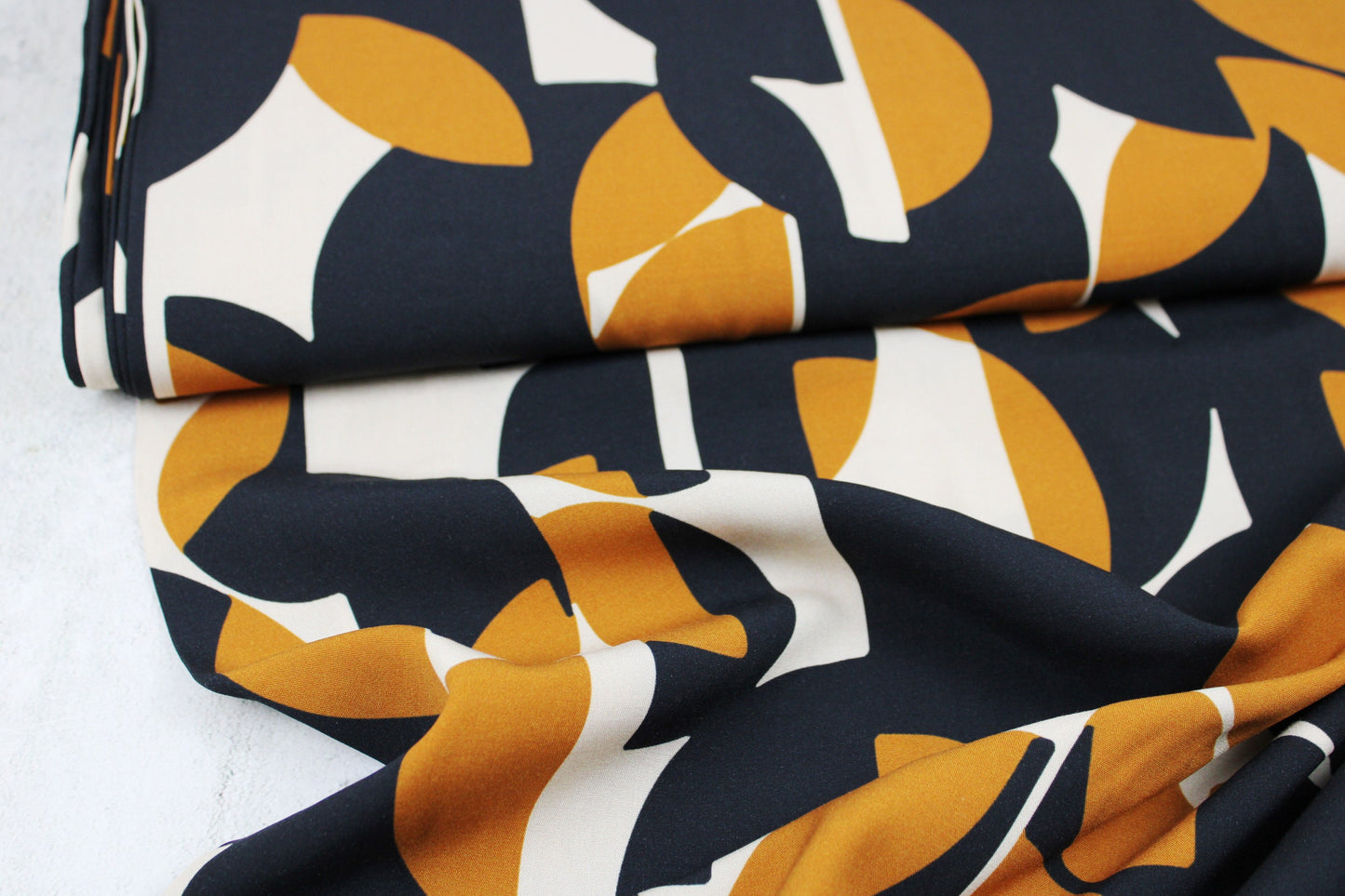 Viskosestoff mit Retromuster in schwarz-ocker-beige Ballenansicht