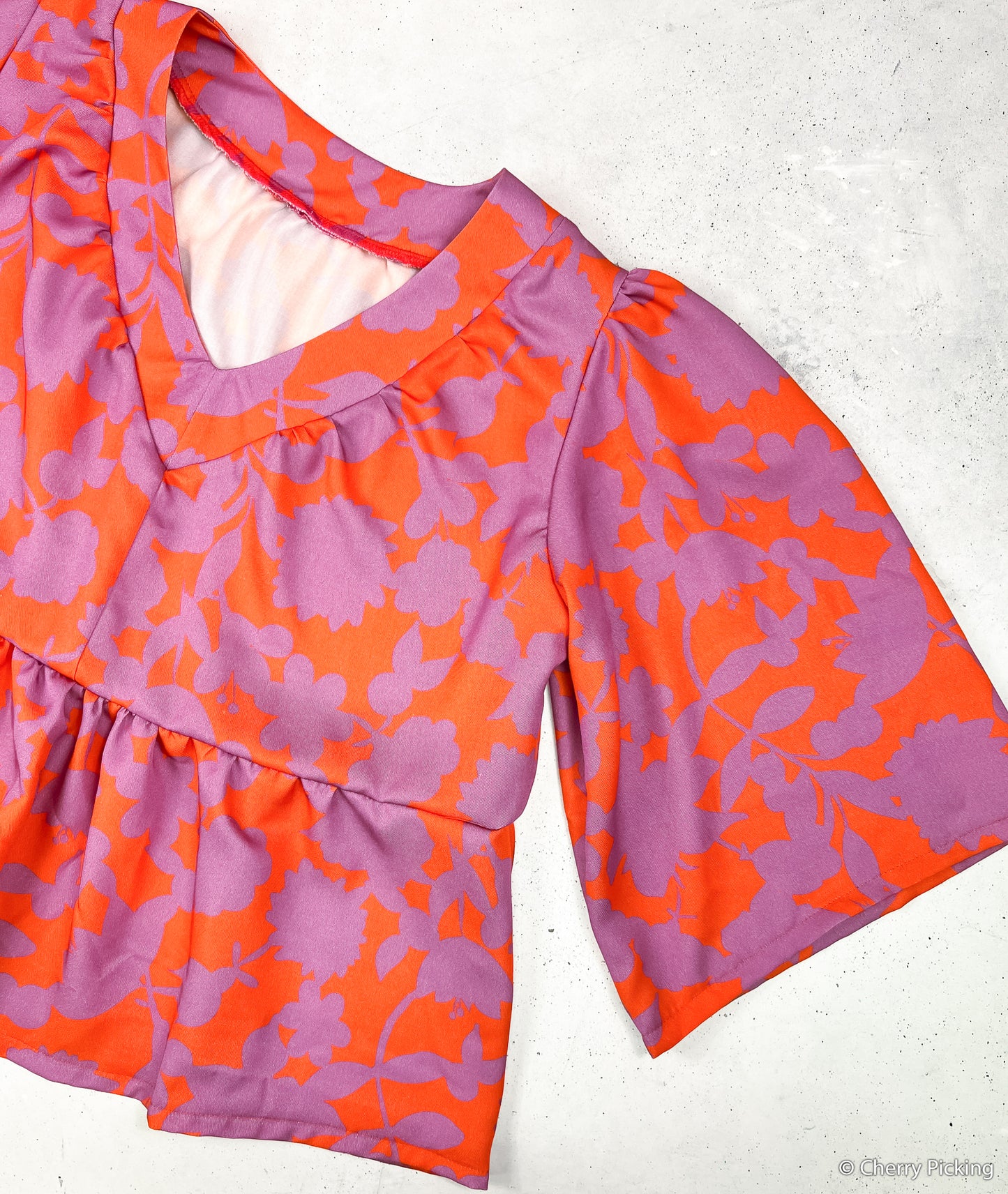 Viskosestoff Happy Flowers mit Blumen in Orange und Flieder als Bluse vernäht