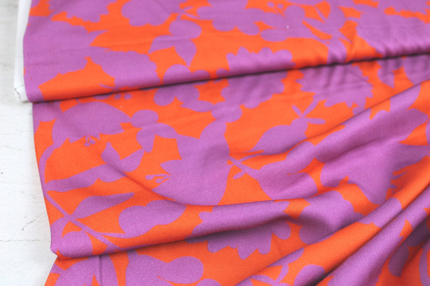 Viskosestoff Happy Flowers mit Blumen in Orange und Flieder Ballenansicht