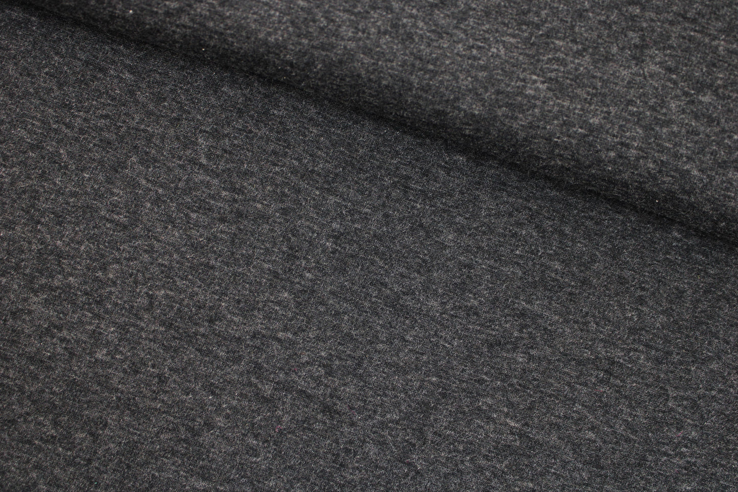 Melierter Alpenfleece Stoff in dunkelgrau mit weißer Fleeceabseite quer