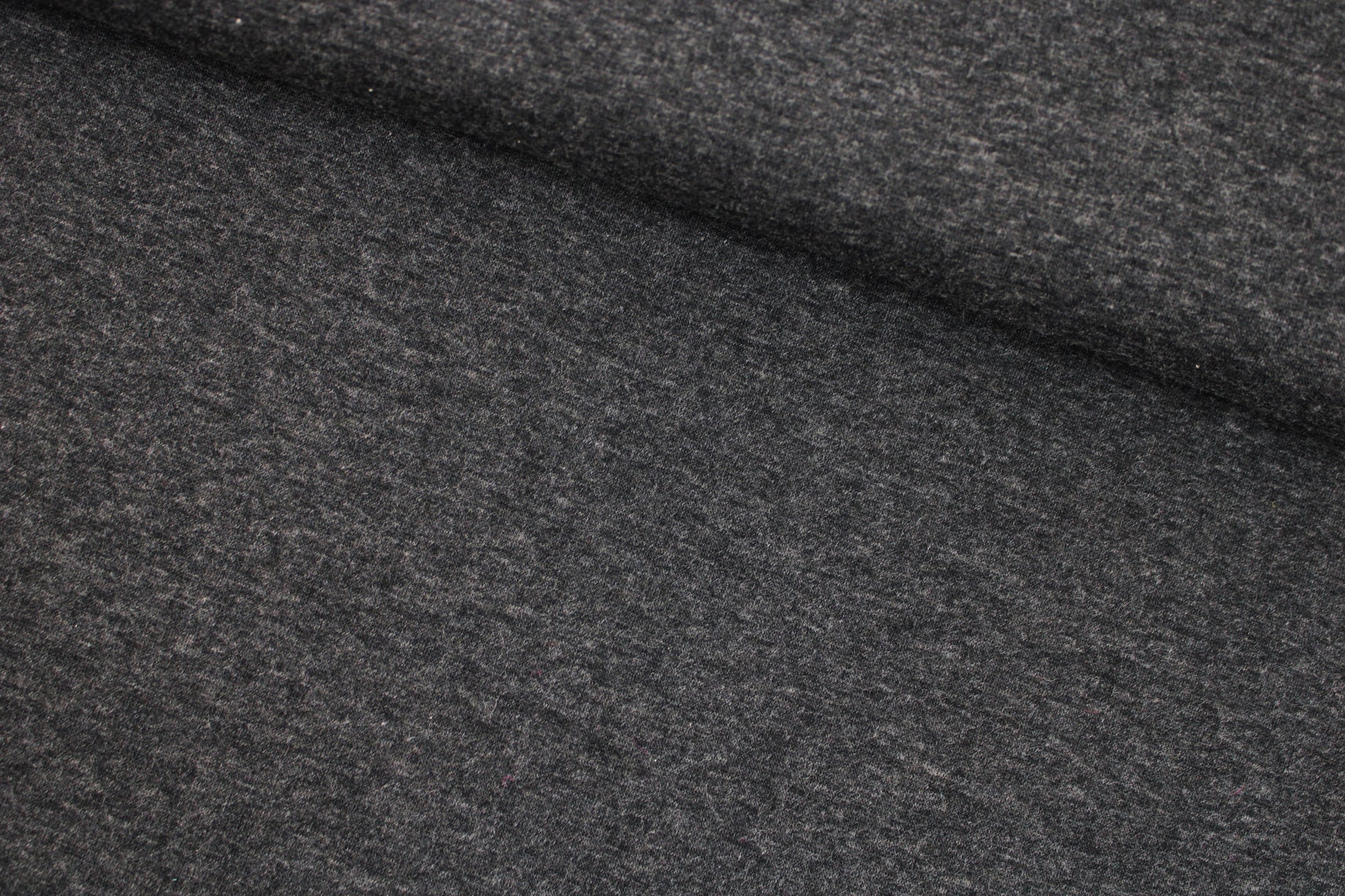 Melierter Alpenfleece Stoff in dunkelgrau mit weißer Fleeceabseite quer