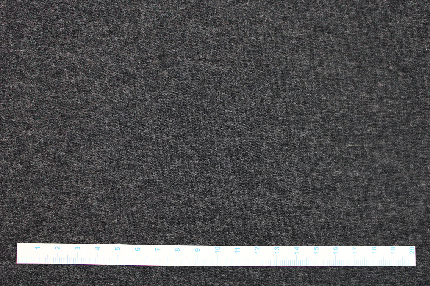 Melierter Alpenfleece Stoff in dunkelgrau mit weißer Fleeceabseite Maßstab