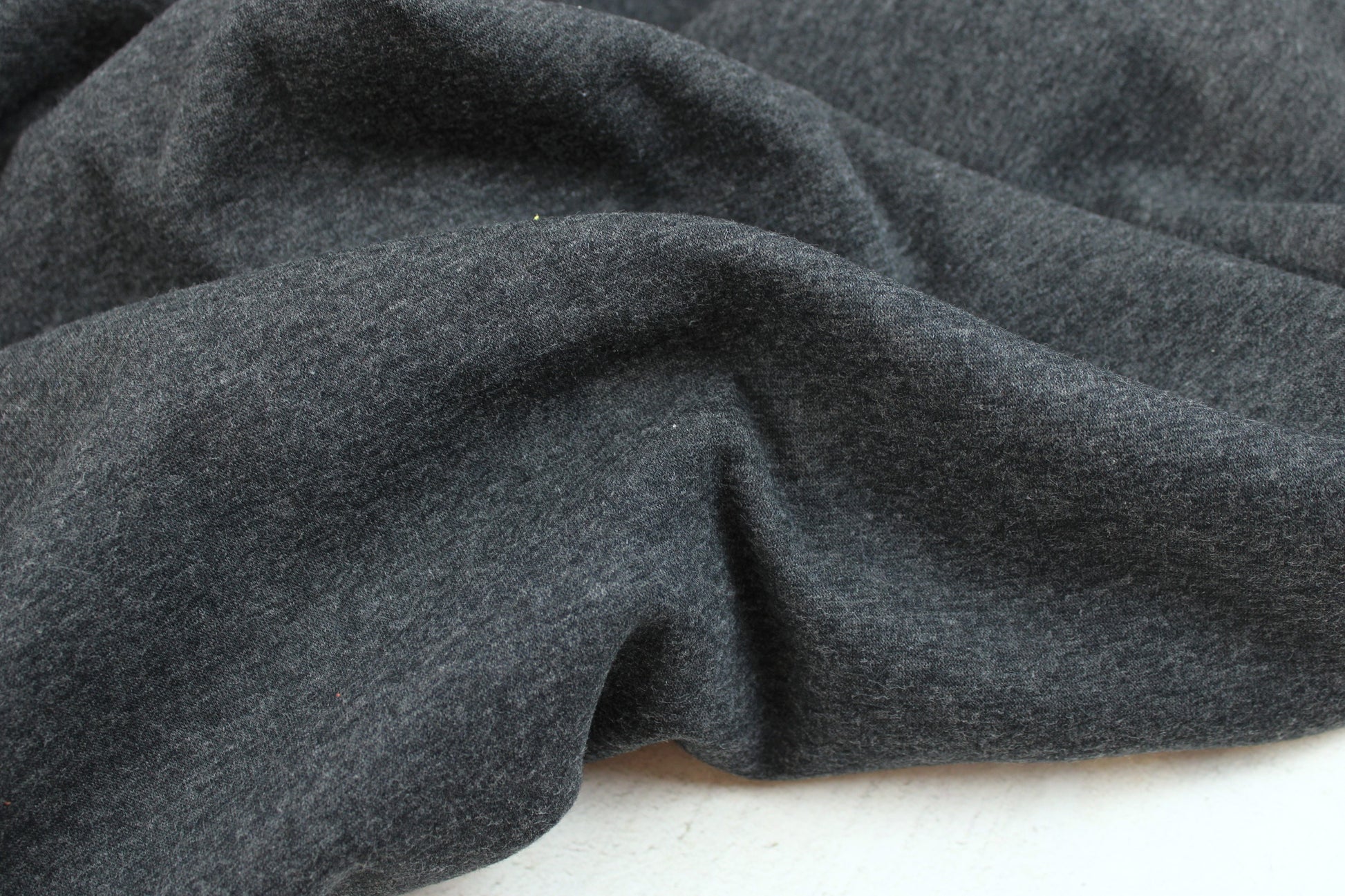 Melierter Alpenfleece Stoff in dunkelgrau mit weißer Fleeceabseite