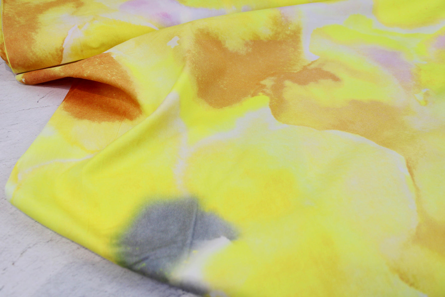 Batistbaumwollstoff mit abstraktem Batikmuster in Gelb- und Rosetönen Ballenansicht