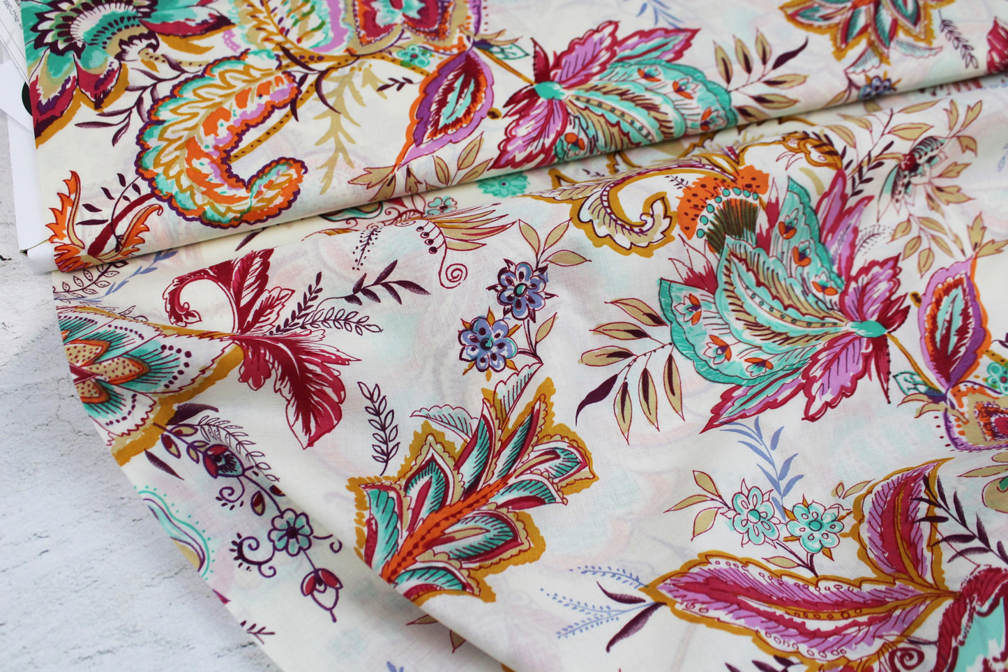 Baumwollbatist mit buntem Paisley-Blumenmuster auf wollweißem Grund Ballenansicht