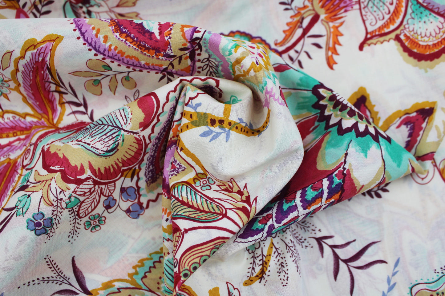 Baumwollbatist mit buntem Paisley-Blumenmuster auf wollweißem Grund gedreht