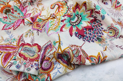 Baumwollbatist mit buntem Paisley-Blumenmuster auf wollweißem Grund