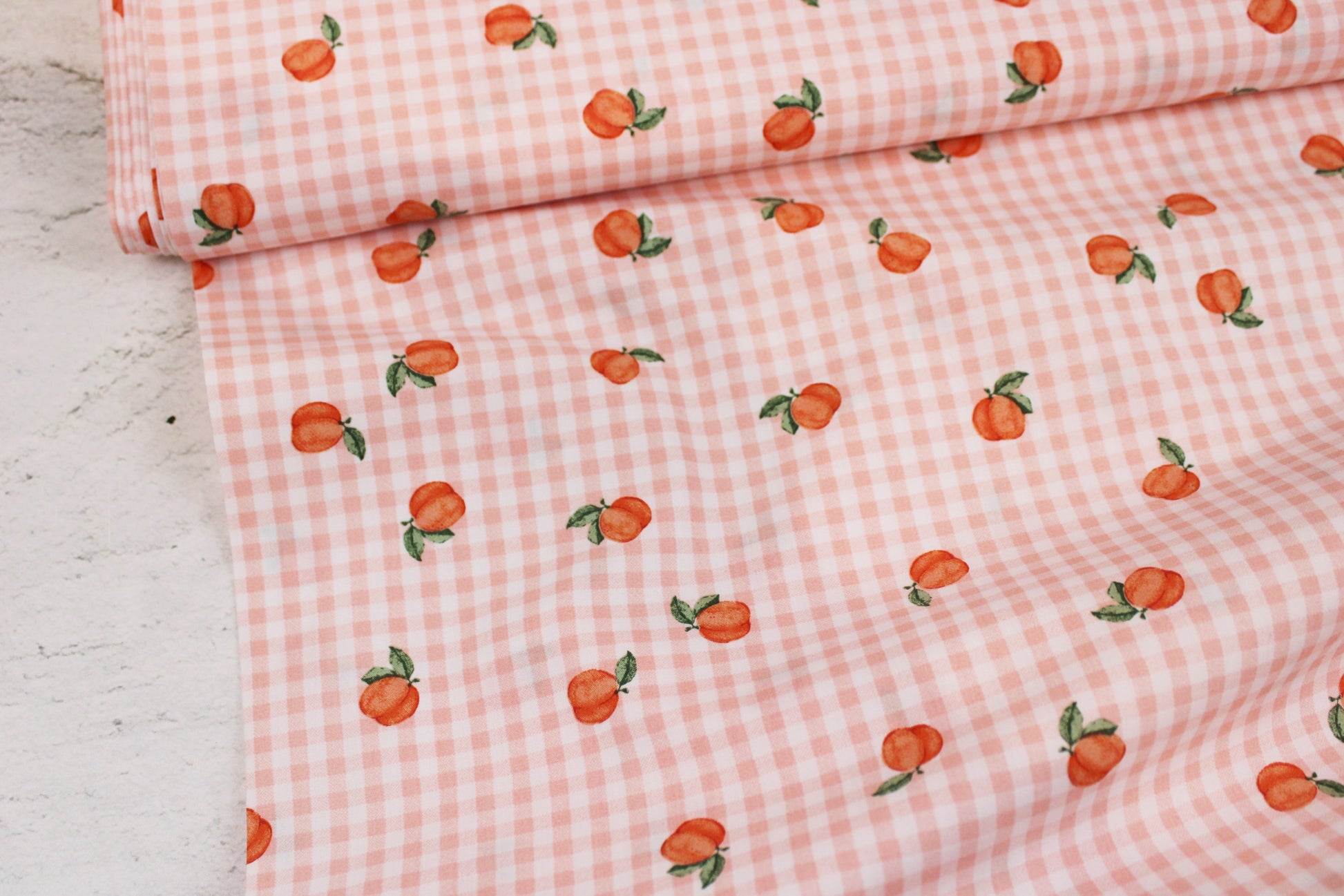 Baumwollstoff Fruta kleine Früchte auf orange-weiß kariertem Grund Ballenansicht