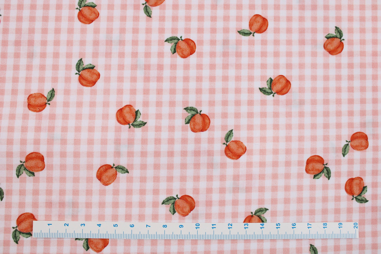 Baumwollstoff Fruta kleine Früchte auf orange-weiß kariertem Grund Maßstab