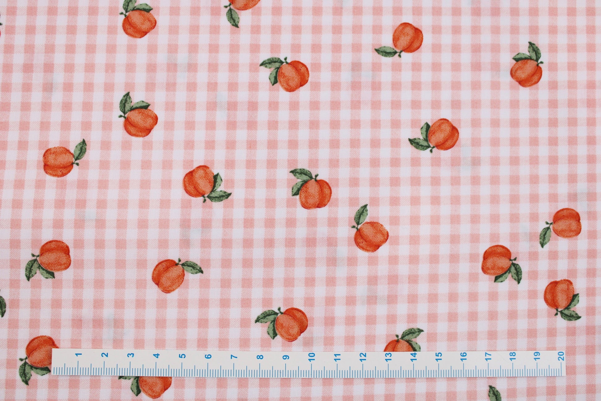 Baumwollstoff Fruta kleine Früchte auf orange-weiß kariertem Grund Maßstab