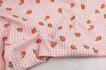 Baumwollstoff Fruta kleine Früchte auf orange-weiß kariertem Grund