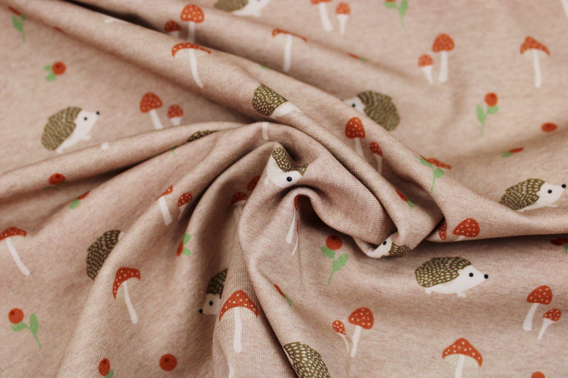 Baumwolljersey Aron mit kleinen Igeln und Pilzen auf Beige farbenem Grund gedreht