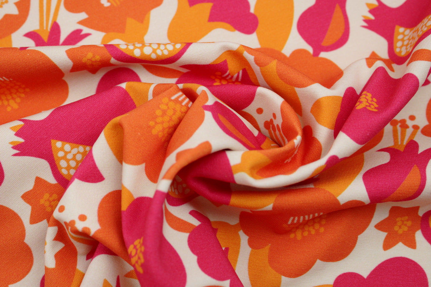 Baumwolljersey mit Retroblumen in Orange- und Pinktönen gedreht