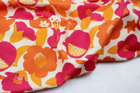 Baumwolljersey mit Retroblumen in Orange- und Pinktönen