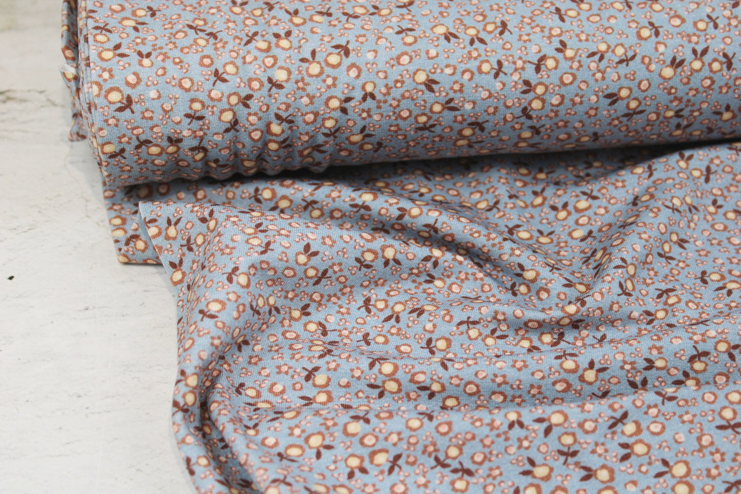 Baumwolljersey Flowers & Wood mit kleinen Blümchen in hellblau und rose Ballenansicht