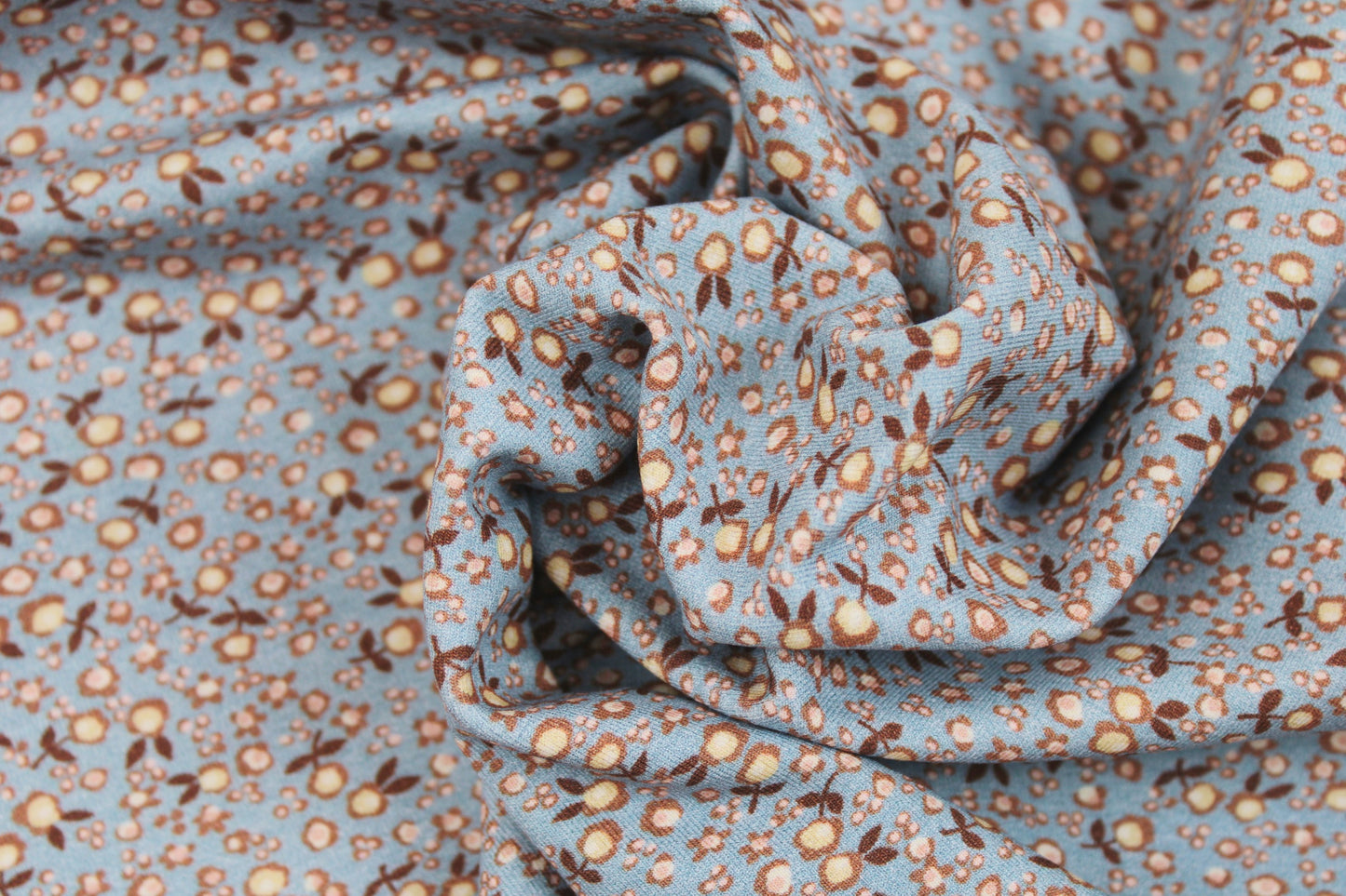 Baumwolljersey Flowers & Wood mit kleinen Blümchen in hellblau und rose gedreht