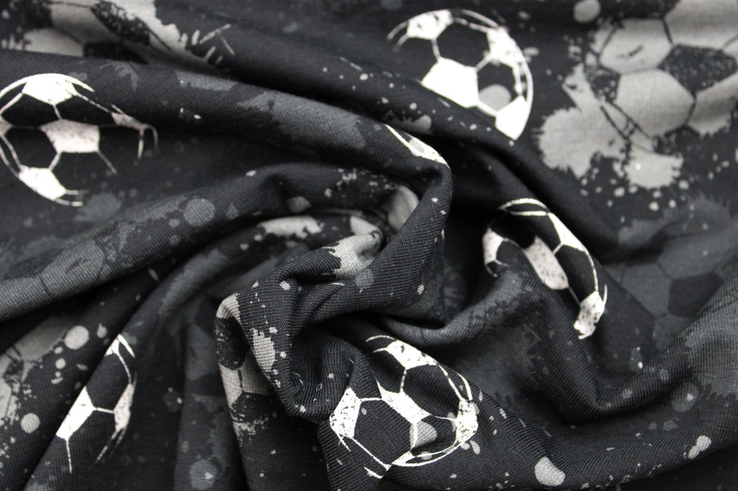 Schwarzer Baumwolljersey mit Fußball-Motiv in grau und weiß gedreht