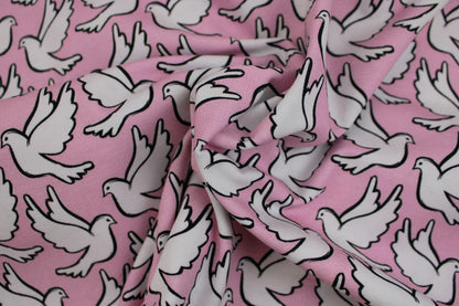 Baumwolljersey Happy Peace & Love mit weißen Tauben auf Rosa Grund gedreht