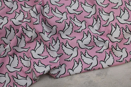 Baumwolljersey Happy Peace & Love mit weißen Tauben auf Rosa Grund