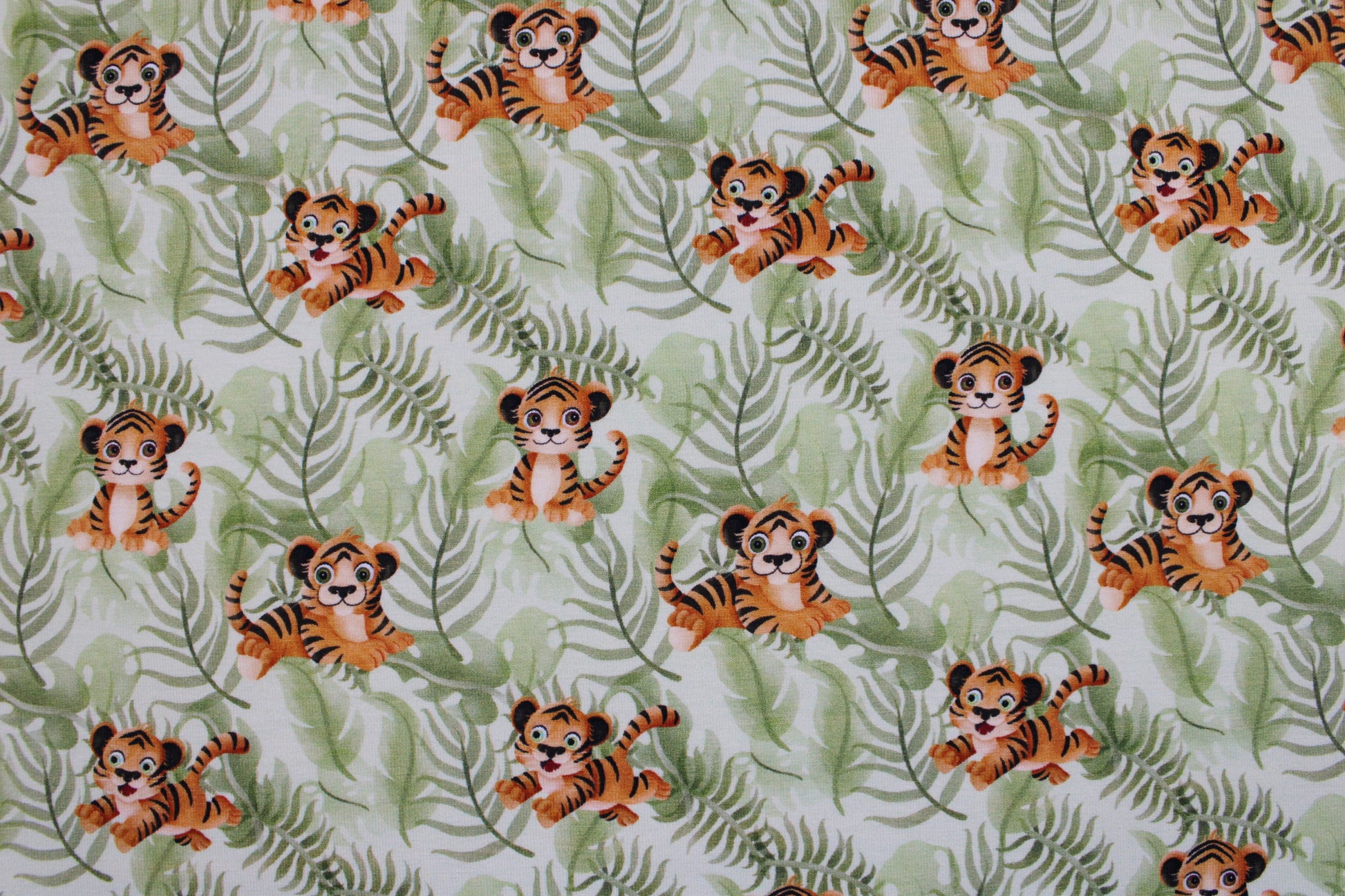 Baumwolljersey mit kleinen Tigern auf grünem Blättergrund Detailbild