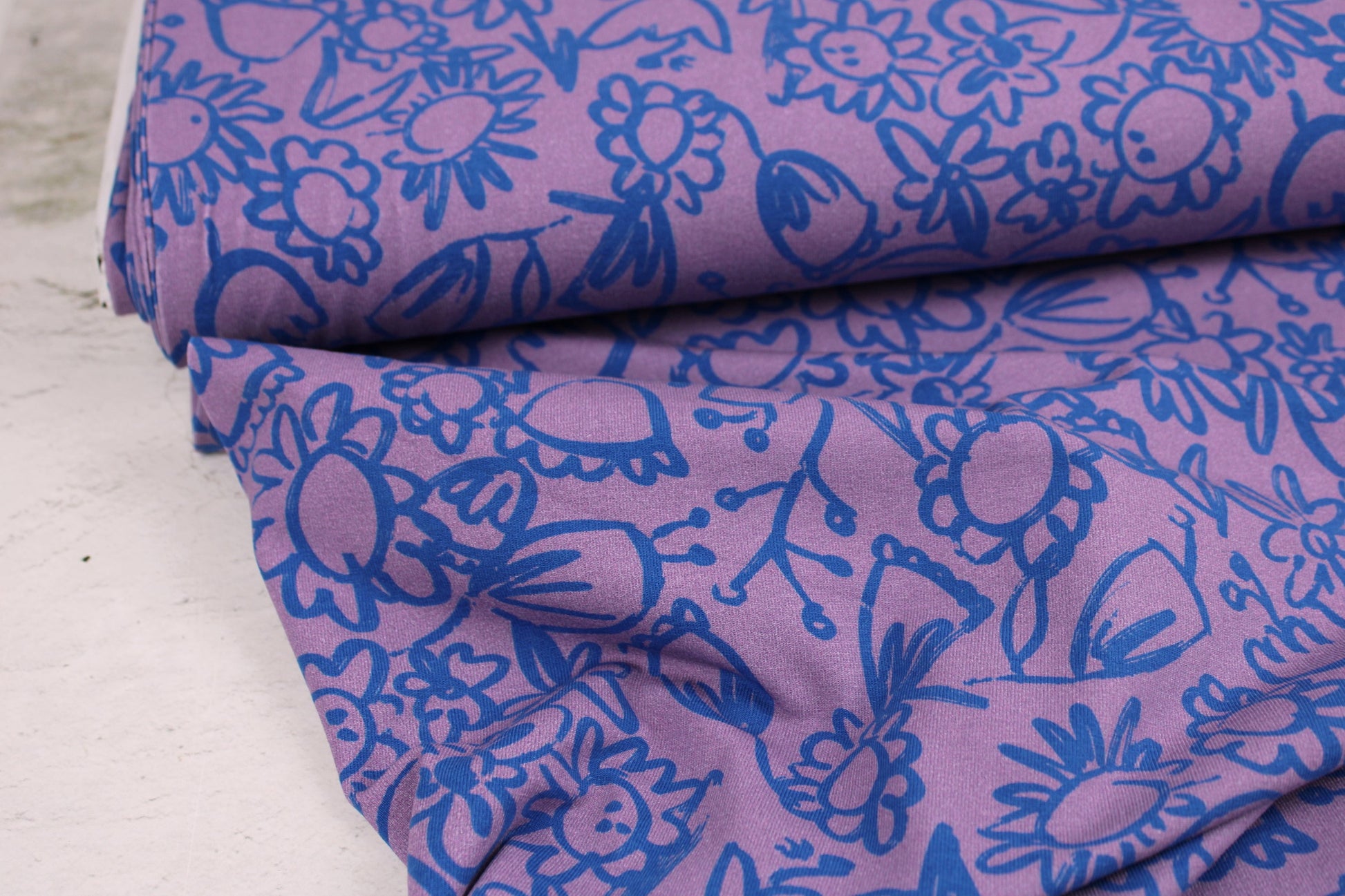 Baumwolljersey Lightness mit Blumenmuster in Lila und Blau Ballenansicht