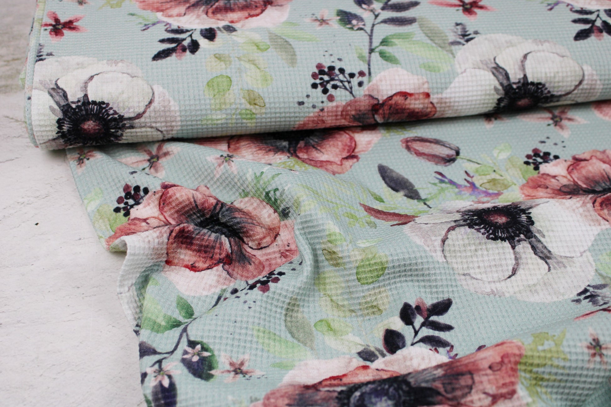 Waffelersey Lisa mit Blumenmuster auf mint farbenem Grund Ballenansicht