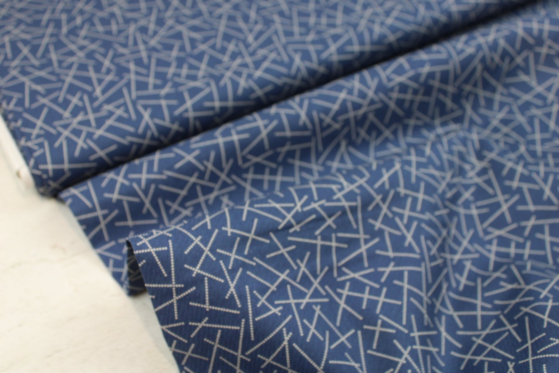 Blauer Baumwollstoff mit hellem Linienmuster Ballenansicht