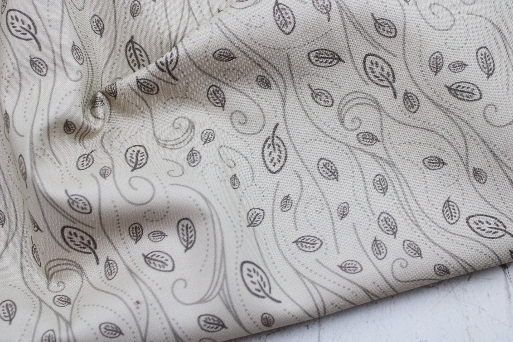 Baumwollstoff mit Blättern in beige aus der Serie Forest Tales