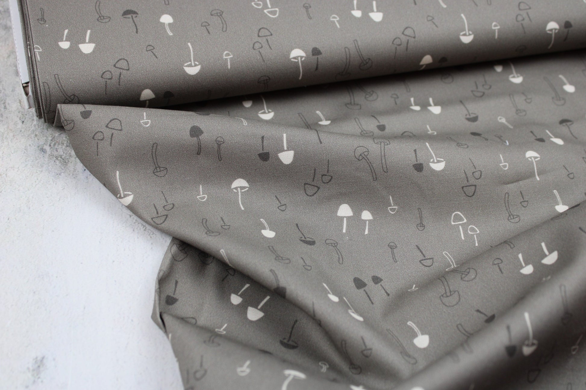 Baumwollstoff mit Pilzen in taupe aus der Serie Forest Tales Ballenansicht