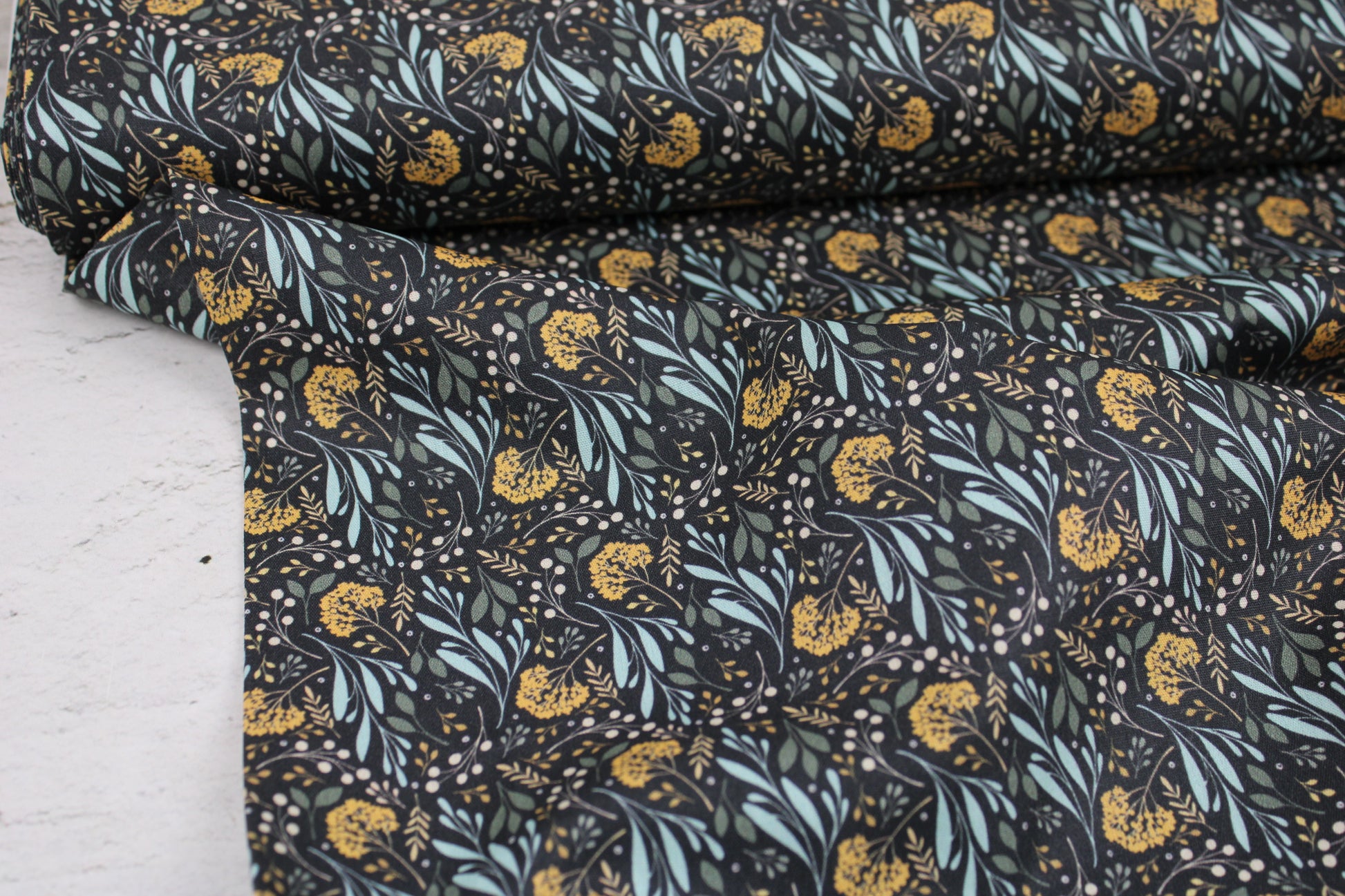 Dunkelgrauer Baumwollstoff Garden of Dreams mit Blumen in Mint und Ocker Ballenansicht