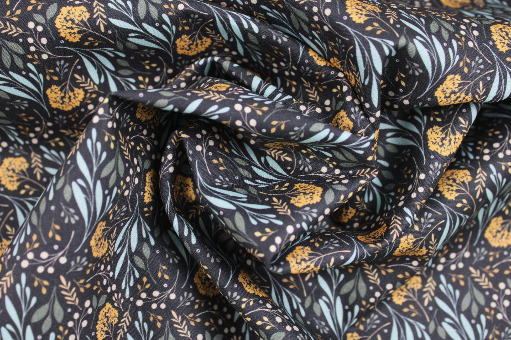 Dunkelgrauer Baumwollstoff Garden of Dreams mit Blumen in Mint und Ocker gedreht