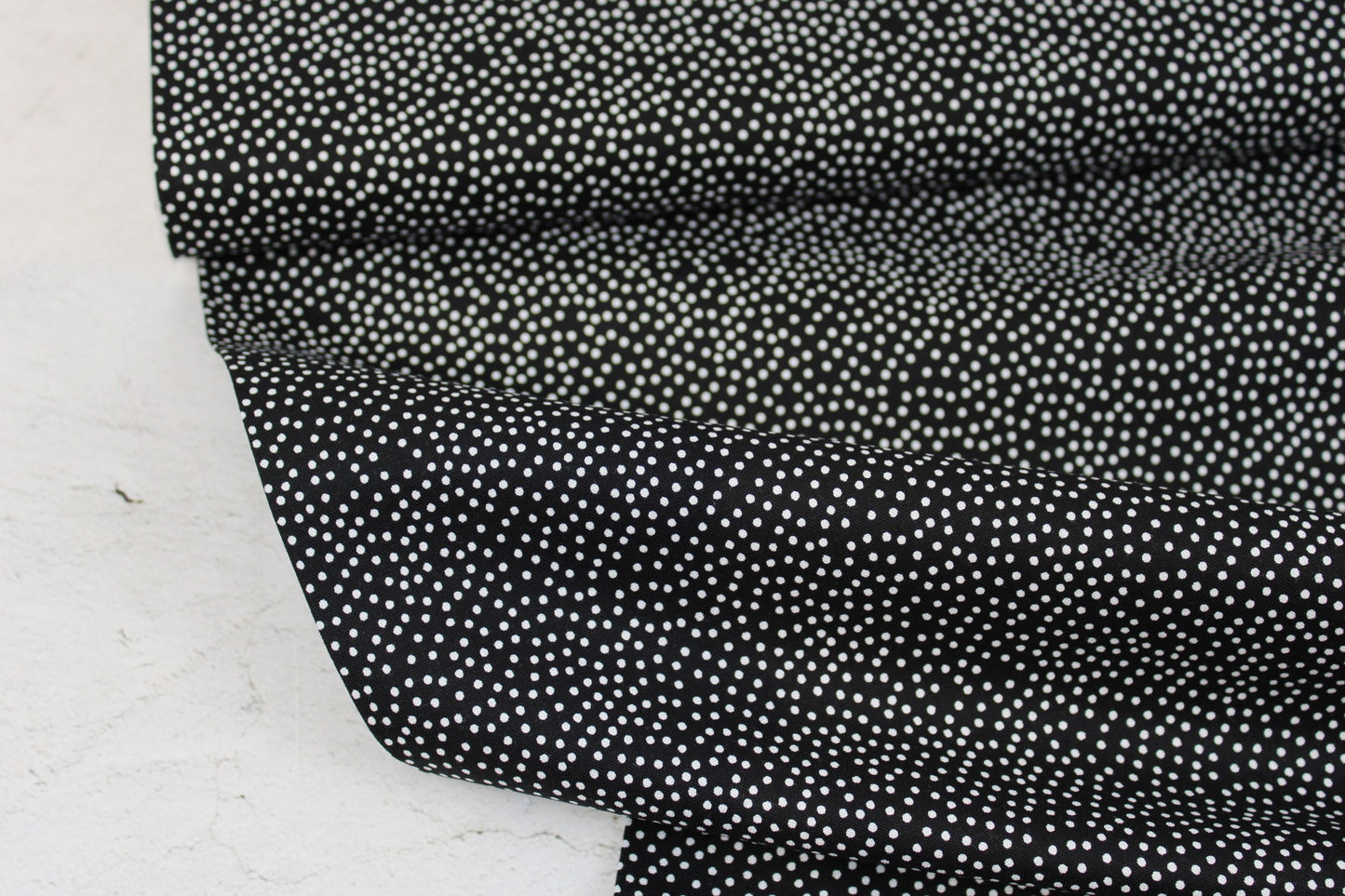 Schwarzer Baumwollstoff Garden Pindot mit kleinen weißen Pünktchen Ballenansicht