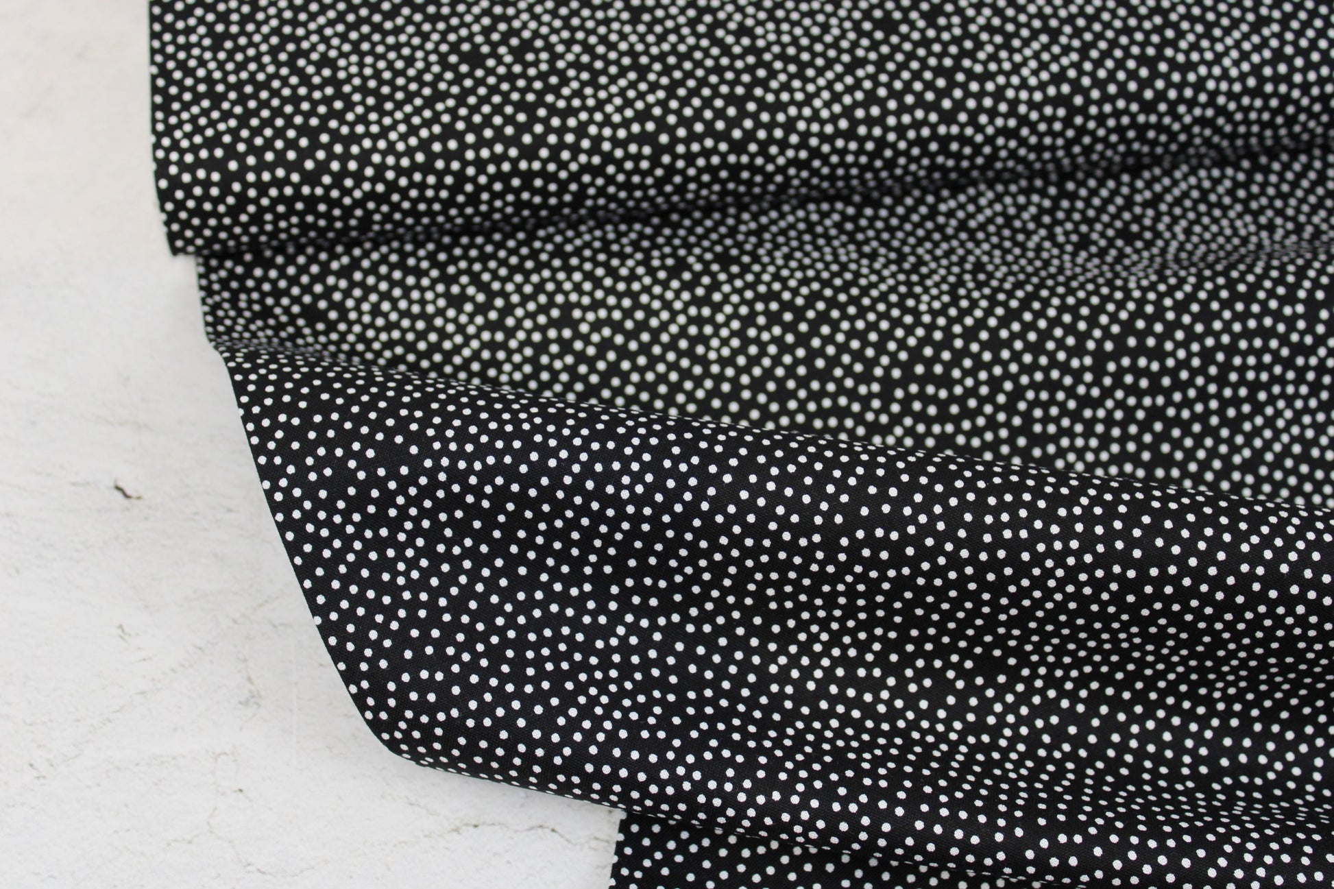 Schwarzer Baumwollstoff Garden Pindot mit kleinen weißen Pünktchen Ballenansicht