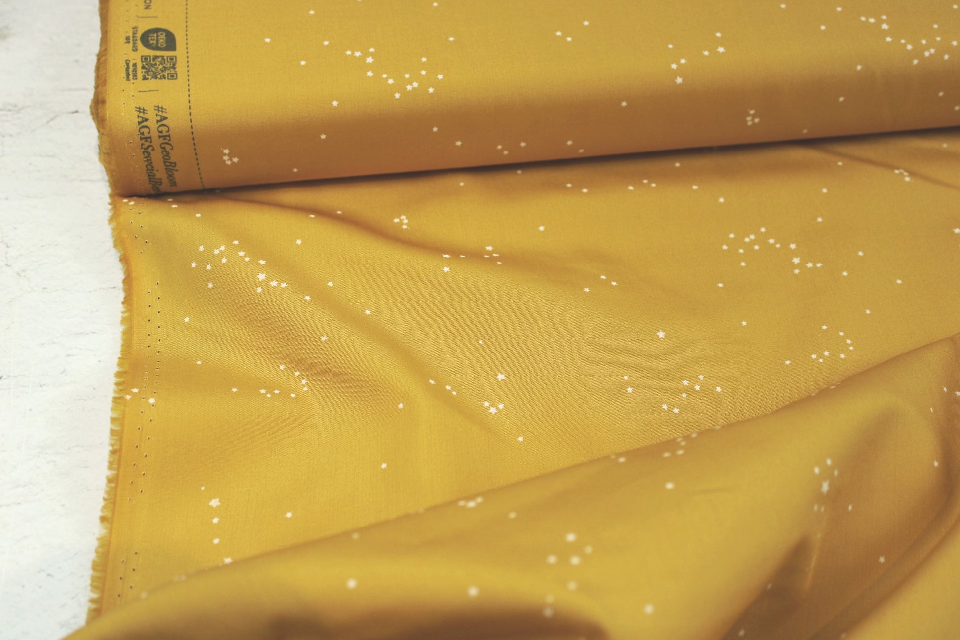 Baumwollstoff Glowdust Golden mit kleinen Sternen aus der Geobloom-Kollektion von Art Gallery Fabrics Detailbild Ballenansicht